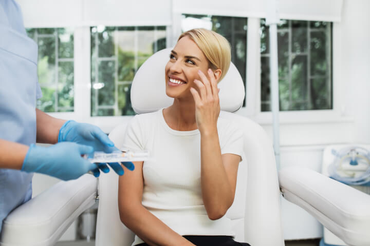 woman consulting with doctor about beauty treatment with dermal fillers 